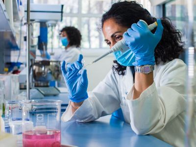 Researcher conducts laboratory research (c) UC Regents. All rights reserved.