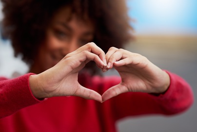 person with raised hands in the shape of a heart