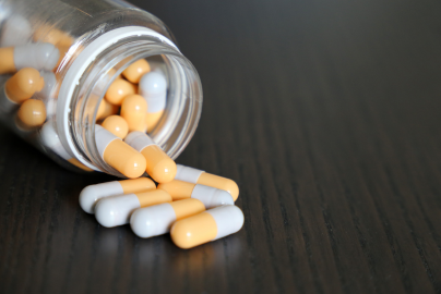 A pill bottle on its side with pills spilled out.