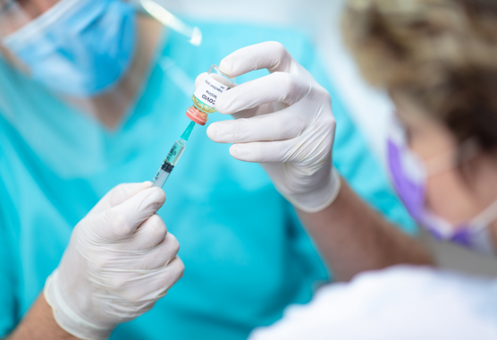 Healthcare worker draws a COVID-19 vaccine for a patient. 