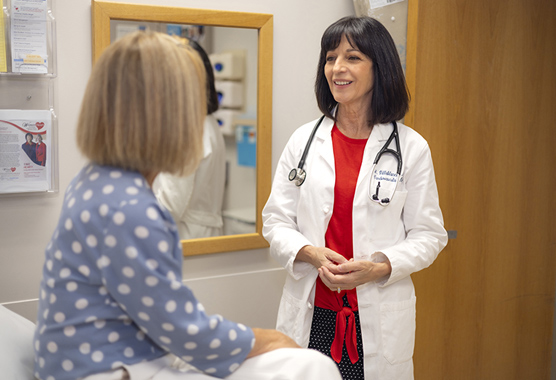 Women’s heart specialist talking about heart disease in women with patient in clinic.