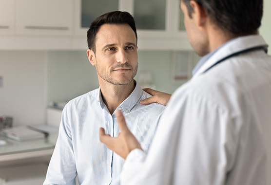 Male patient listening to health care provider talk to him about Huntington’s Disease.