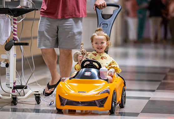 Young surgery patient smiling while being pushed in a cart in the hospital