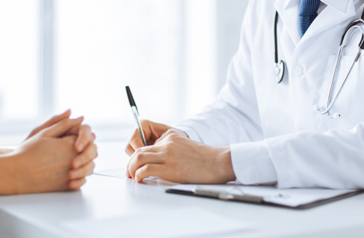 Health care provider talking with patient about thyroid nodule ablation while sitting at a desk.