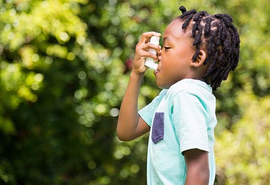 Boy using an asthma inhaler