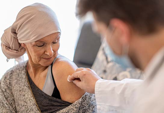 Adult woman receiving vaccine from doctor