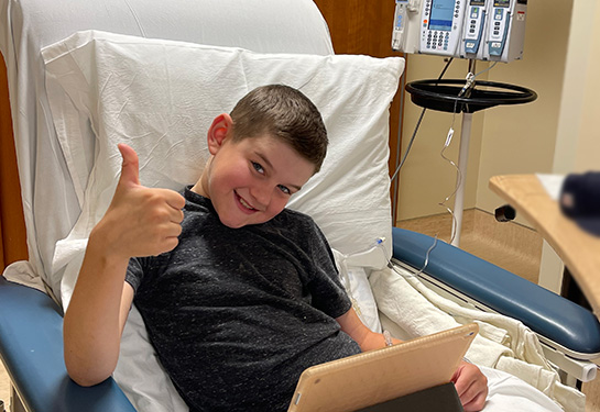 Young male in a hosptial bed using an ipad