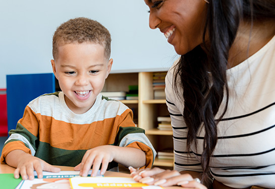 Young boy imitates emotion on flash cards