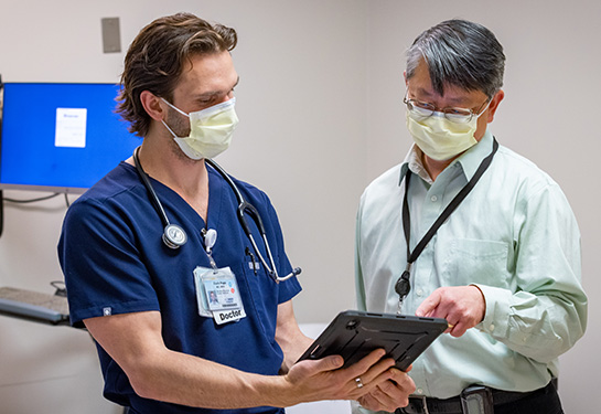 resident and doctor speaking in patient room