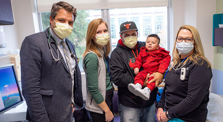Parent and baby with clinic staff in the cardiology clinic
