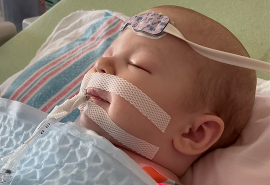 Ellie in a hospital bed smiling