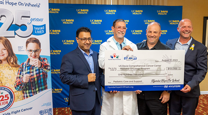 Four men holding a check