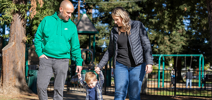 Man and woman hold hands with child