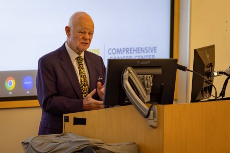 Man with white hair at podium