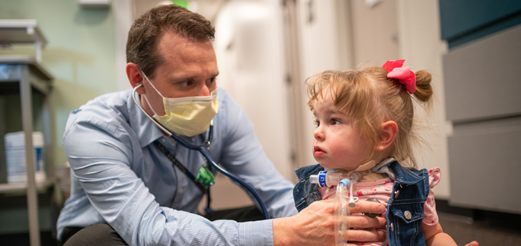 Man with mask with toddler girl
