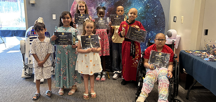 8 children stand holding certificates