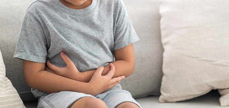 Sick boy touching belly stomach