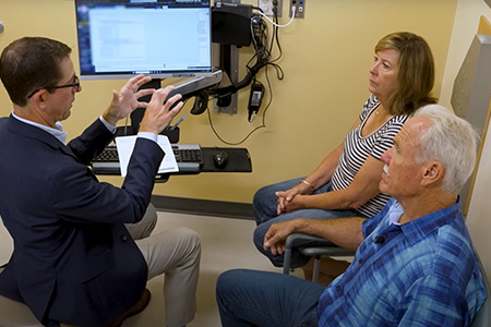 Urologic surgeon Marc Dall’Era explaining to a couple about prostate cancer.