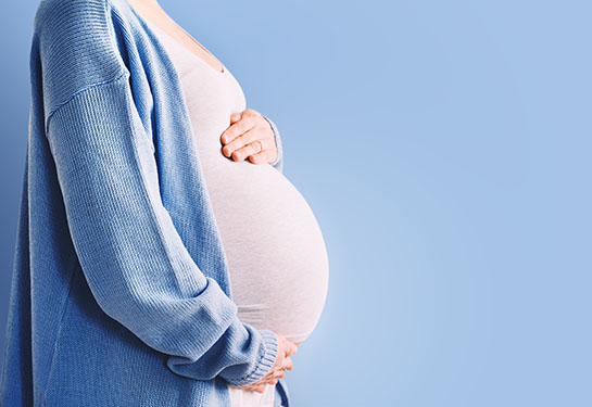 A pregnant woman holding her stomach.