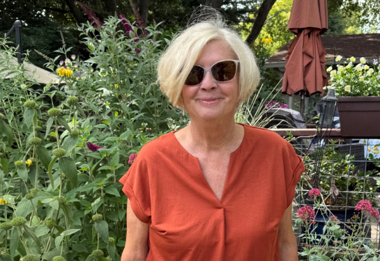 Barbara Tiney wearing sunglasses and standing in a garden. 