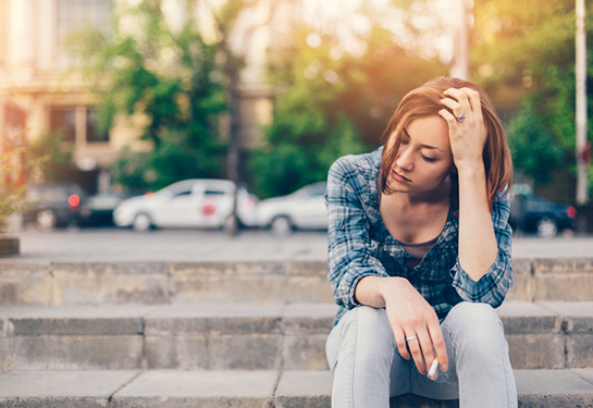 Unhappy thoughtful girl with cigarette 