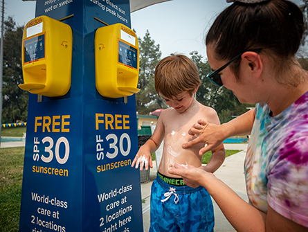 a mom putting sunscreen on her young son