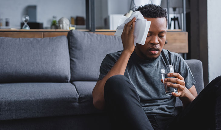 man holding ice to his head at home