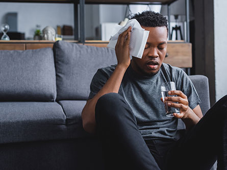 man putting ice on his head at home