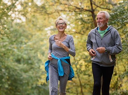 senior man and woman walking in a park