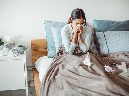 woman sick in bed with the flu