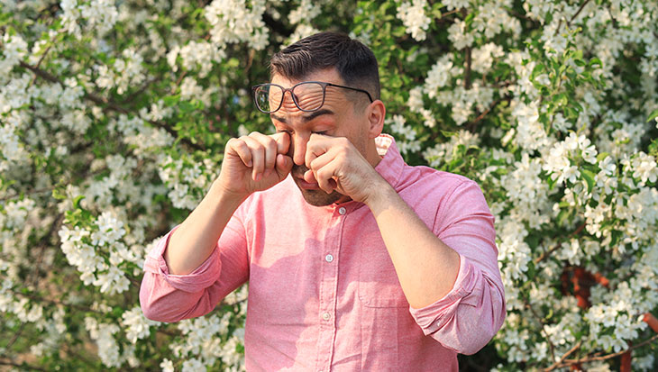 man rubbing his eyes