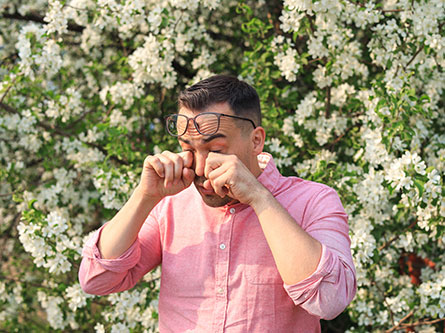man rubbing his eyes