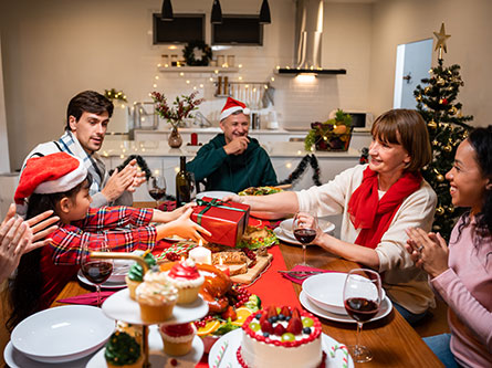 smiling family and friends sitting at a table and smiling for Christmas dinner