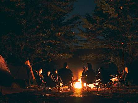 people gathered around a campfire at night and ways to treat burns
