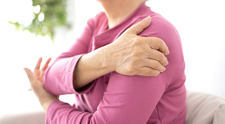 woman holding her shoulder with shoulder arthritis