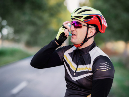 Cyclist using asthma inhaler.