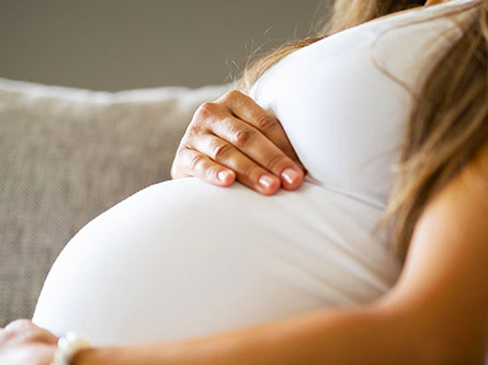 Pregnant person holding thier belly