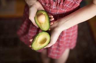 woman holding avocado