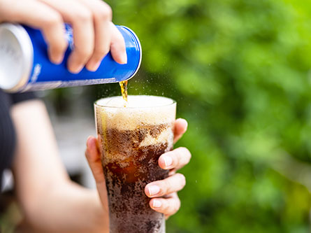 person pouring soda in a glass