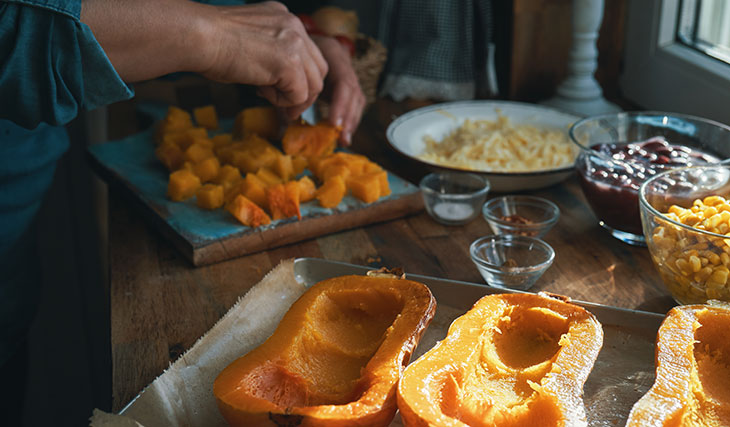 person preparing winter squash in a kitchen