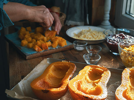 person preparing winter squash in a kitchen
