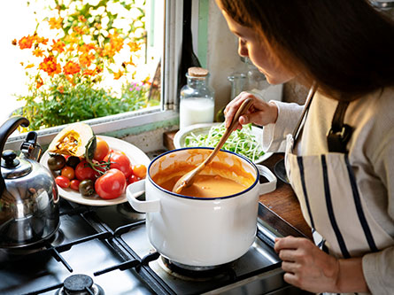 woman making soup on a stove