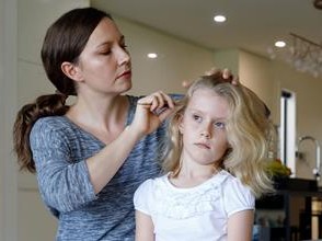 Mom brushing out lice from hair