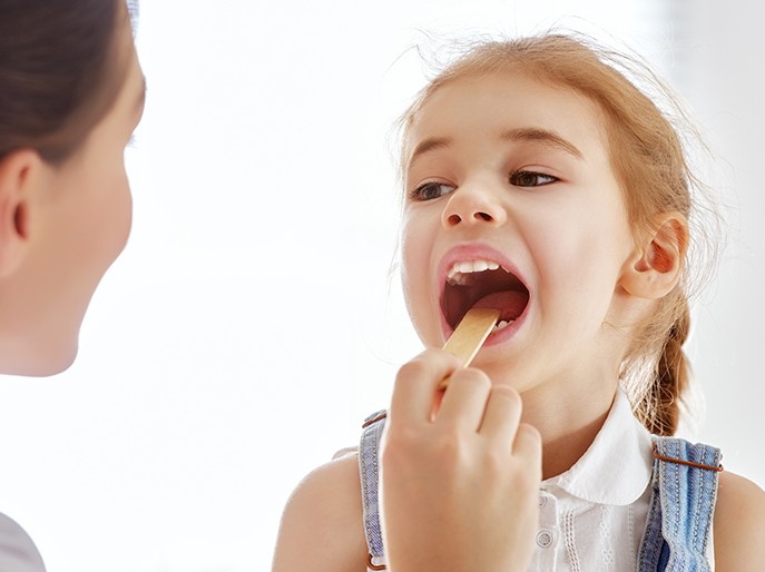 girl having tonsils examined
