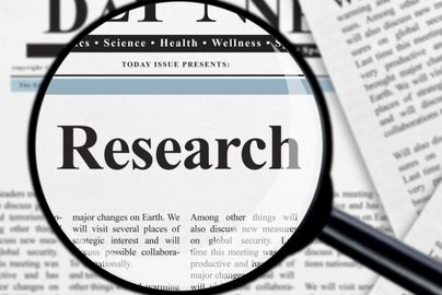 the word research inside a magnifying glass