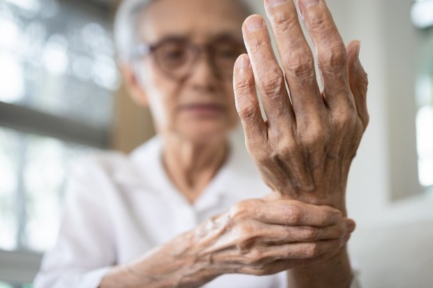 Elderly woman holding her hand in pain