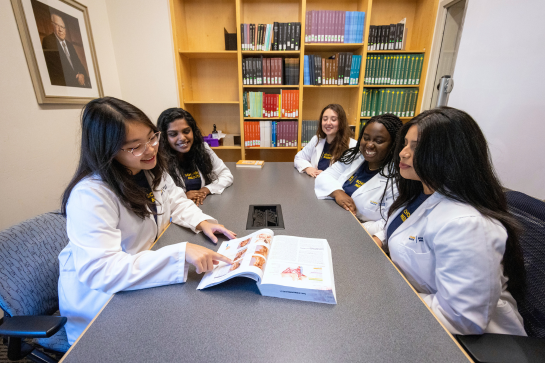 Medical students study at a library table. 